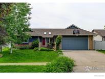 Charming single-story home featuring a well-manicured lawn and a two-car garage with a basketball hoop at 901 Welch Ave, Berthoud, CO 80513