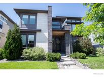 Modern two-story home featuring a well-manicured lawn and contemporary architectural design at 9415 E 58Th Dr, Denver, CO 80238
