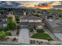 Beautiful two-story home with professionally landscaped front yard and mountain views at sunset at 9527 Loveland Way, Arvada, CO 80007