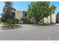 Beautiful building featuring mature trees, a circular drive, and well-manicured landscaping at 14000 E Linvale Pl # 210, Aurora, CO 80014