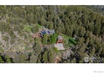 Aerial view of house and garage featuring solar panels, surrounded by trees at 172 Tall Pine Ln, Boulder, CO 80302
