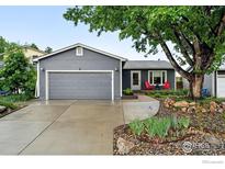 Charming single-story home features a gray exterior, two-car garage, and landscaped front yard at 311 S Adams Dr, Louisville, CO 80027