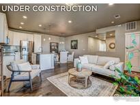 Cozy living room with modern furnishings, open floor plan, and hardwood floors under construction at 410 High Point Dr # 102, Longmont, CO 80504