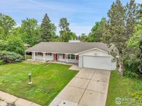 Charming single-story home with brick exterior, lush lawn, and a basketball hoop above the garage at 6524 E Alaska Dr, Denver, CO 80224