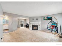 Spacious living room featuring a cozy fireplace and neutral carpeting at 6710 W 84Th Way # 19, Arvada, CO 80003