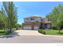 Charming two-story home with a brick facade, three-car garage, and beautifully landscaped front yard at 7858 Oban Ct, Lone Tree, CO 80124
