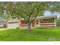 Charming single-story brick home featuring a lush front lawn and mature shade tree at 1025 Edinboro Dr, Boulder, CO 80305