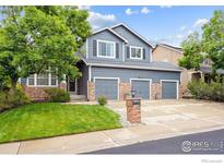 Charming two-story home with a three-car garage, brick accents, and a well-maintained lawn at 13560 Detroit St, Thornton, CO 80241