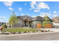 Stunning exterior view of home featuring professionally landscaped front yard, stone accents, and a spacious driveway at 1366 Eliza Ave, Berthoud, CO 80513