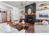 Bright living room features a fireplace, floating shelves, and a stylish light fixture at 1366 Eliza Ave, Berthoud, CO 80513