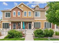 Charming townhome with a welcoming front porch and a well-maintained garden and white picket fence at 16031 W 63Rd W Ln # D, Arvada, CO 80403