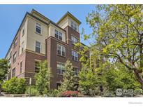 A beautiful red brick and tan stucco multi-story condo building with well-maintained landscaping and mature trees at 1623 Saint Paul St # 310, Denver, CO 80206