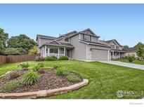 Charming two-story home boasts a well-manicured lawn and inviting curb appeal at 1641 Cedarwood Dr, Longmont, CO 80504