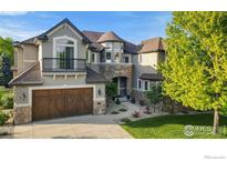 Beautiful two-story home featuring a stone facade, a balcony, and a well-manicured front yard at 1644 Stardance Cir, Longmont, CO 80504