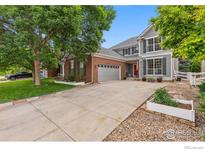 Charming two-story home with a well-maintained lawn, mature trees, and an attached two-car garage at 1706 Naples Ln, Longmont, CO 80503