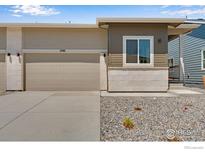 Inviting home featuring a two-car garage, neutral color palette, and modern architectural details at 1790 Mount Meeker Ave, Berthoud, CO 80513