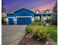 Beautiful blue home with well-maintained landscaping, stone accents, and a spacious three-car garage at 1874 Ute Creek Dr, Longmont, CO 80504