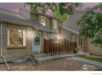 Charming townhouse featuring a brick facade and a cozy front porch with a decorative wreath at 2108 Meadow Ct, Longmont, CO 80501