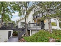 Charming home featuring a multi-level deck, mature trees, and professionally landscaped yard at 3260 Lafayette Dr, Boulder, CO 80305
