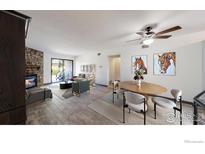 Bright living room featuring a stone fireplace, stylish furnishings, and sliding glass doors to the outdoors at 3526 S Depew St # 102, Lakewood, CO 80235