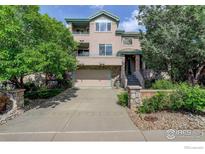 Two-story home featuring a front yard, multi-car garage, second-floor balcony and decorative stone elements at 710 Inca Pkwy, Boulder, CO 80303