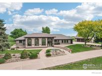 Stunning exterior view with manicured landscaping and a charming fountain feature and attached garage at 10141 Yellowstone Rd, Longmont, CO 80504
