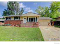 Charming single-story home with brick accents, lush green lawn, and inviting curb appeal on a sunny day at 112 Dawson Pl, Longmont, CO 80504