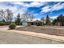 Charming brick home with a well-manicured front yard and detached red shed at 12891 Columbine Dr, Longmont, CO 80504