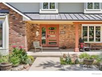 Charming brick home featuring a modern front door with sidelights and a welcoming front porch at 1579 W Costilla Pl, Littleton, CO 80120