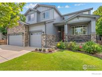Charming two-story home with stone accents, attached garage, and a beautifully landscaped front yard at 1682 Crestview Ln, Erie, CO 80516
