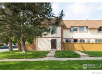 Charming townhome featuring a well-maintained lawn, quaint fence, and a welcoming front entrance at 1901 W 101St Ave, Thornton, CO 80260