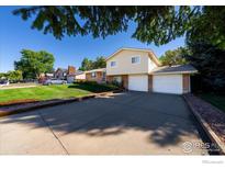 Charming two-story home with a well-manicured lawn and a spacious driveway leading to a two-car garage at 2132 Gay St, Longmont, CO 80501