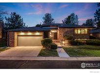 Charming brick home with attached two-car garage, inviting front yard, and pathway leading to the entrance at 2777 S Elmira St # 17, Denver, CO 80231