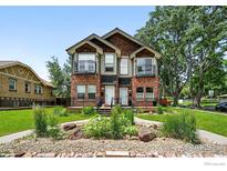 Beautiful brick townhome featuring a landscaped front yard and dual balconies, perfect for enjoying the neighborhood at 4039 N Clay St, Denver, CO 80211