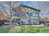 An exterior view of the back of this home highlights a spacious deck and well-maintained lawn at 456 W Sycamore Ct, Louisville, CO 80027