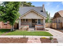 Charming brick home featuring a well-maintained lawn and inviting front porch at 4594 Beach Ct, Denver, CO 80211