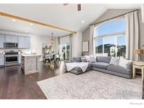 Bright, open-concept living room featuring hardwood floors, a vaulted ceiling, and ample natural light at 675 Lene Ln, Berthoud, CO 80513