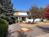 Charming two-story home with landscaped yard and a circular gravel driveway at 6969 Harvest Rd, Boulder, CO 80301