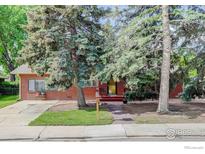 Charming brick home with mature trees, sidewalk, and cozy front porch at 915 19Th Ave, Longmont, CO 80501