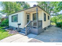 Charming single Gathering home with a cozy front porch, manicured lawn, and mature trees at 1233 Carolina Ave, Longmont, CO 80501