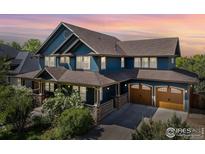 Stunning blue two-story home with a covered porch, an attached two-car garage, and mature landscaping at 1279 Greening Ave, Erie, CO 80516