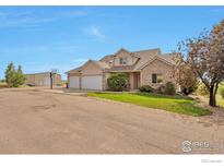 Charming two-story home boasts a brick and stucco exterior with a three car garage and additional metal building at 14825 Almstead St, Hudson, CO 80642