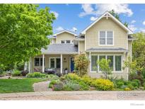 Charming two-story home features a landscaped front yard and inviting front porch with comfortable seating at 1509 Poplar Ave, Boulder, CO 80304