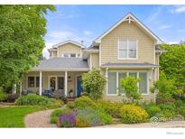Charming two-story home with landscaped yard, inviting porch, and blue front door at 1509 Poplar Ave, Boulder, CO 80304