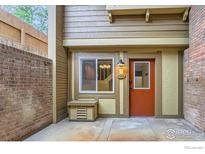 Charming townhouse front entrance with red door, brick facade, and exterior window at 3161 Madison Ave # 108, Boulder, CO 80303