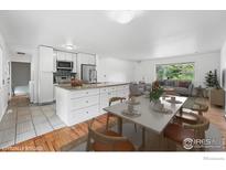 Bright dining area and kitchen featuring white cabinets, granite counters and stainless steel appliances at 4462 Hamilton Ct, Boulder, CO 80305
