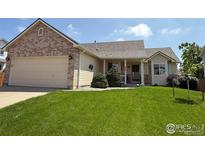 Charming single-Gathering home with well-manicured lawn and inviting front porch at 526 Badger Creek Dr, Brighton, CO 80601