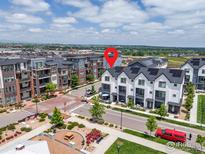 Stunning aerial view of modern townhomes in a vibrant community with parks and green spaces on a sunny day at 605 Promenade Dr, Superior, CO 80027