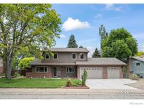 Charming two-story home featuring a manicured lawn and a three-car garage at 7409 Mount Meeker Rd, Longmont, CO 80503