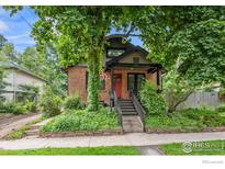 Charming brick home with mature trees, lush landscaping, and inviting front porch at 1010 Euclid Ave, Boulder, CO 80302